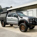 Boss cab rack fitted to a silver Ford F-250/F-350 Super Duty with canopy, front three-quarter view