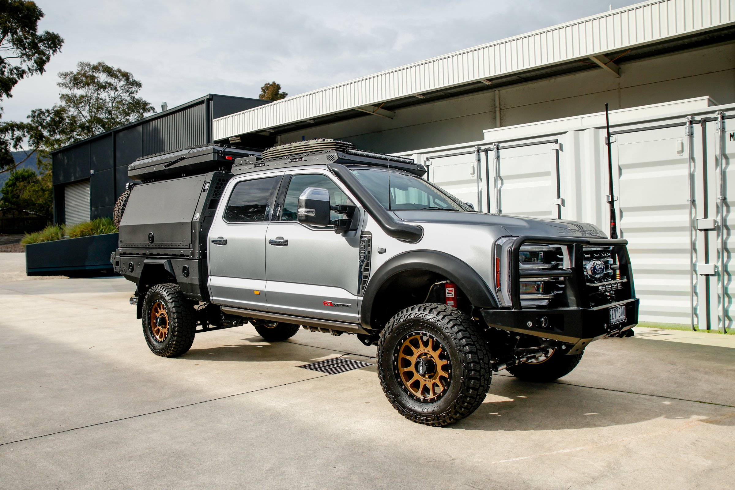 Boss cab rack fitted to a silver Ford F-250/F-350 Super Duty with canopy, front three-quarter view