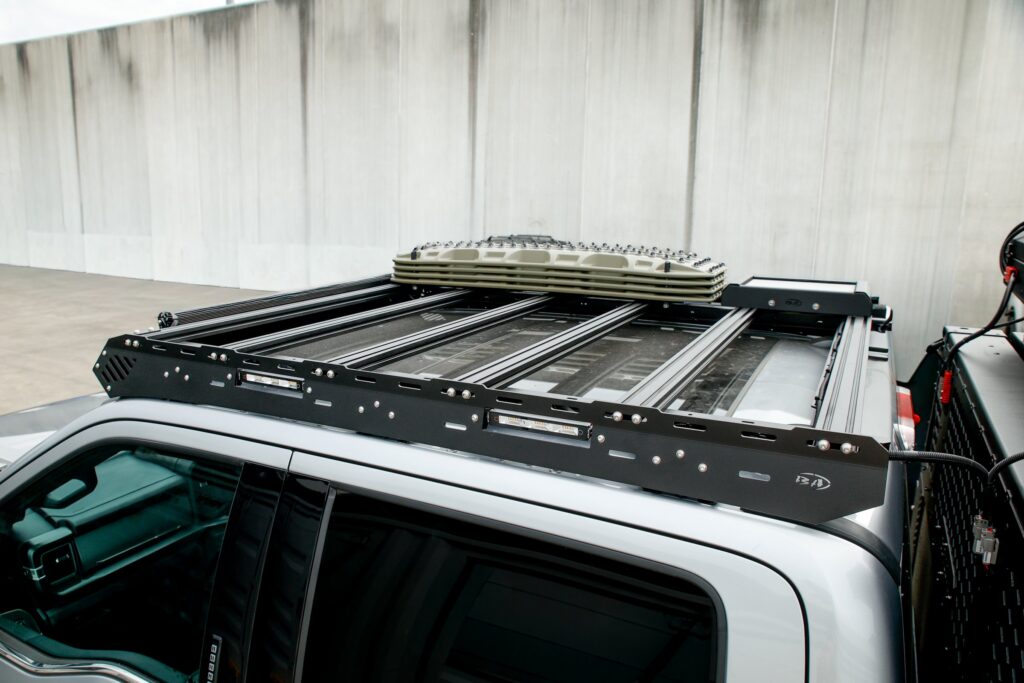 Close-up of the Boss Ford F-250/F-350 cab rack platform with recovery boards and integrated LED light bars