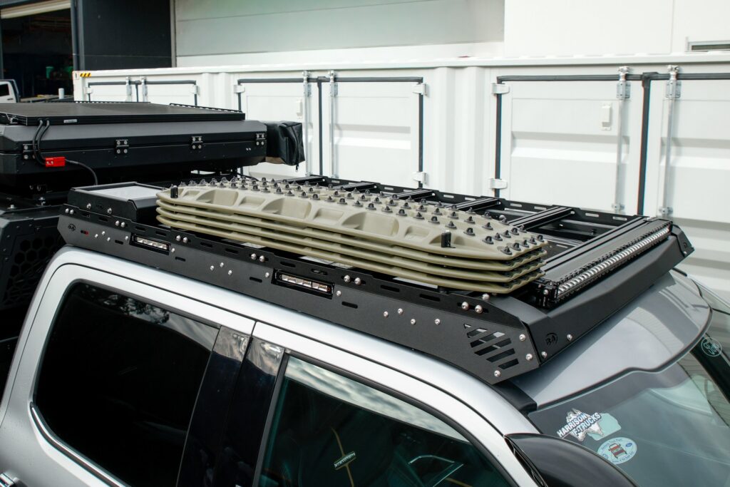 Boss Ford F-250/F-350 cab rack loaded with recovery boards and a roof-top tent, side view