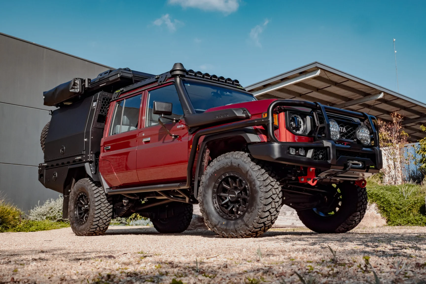Red Toyota LandCruiser 79 dual cab with a Boss tray, canopy and cab rack